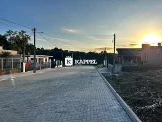 Vista da entrada de uma propriedade em Lajeado, com um caminho de paralelepípedos.
