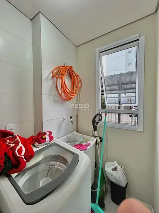 Foto interna de um banheiro com azulejos brancos e janela.