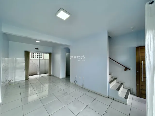 Corredor com piso de cerâmica branco que leva a uma área de banheiro.