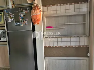 Foto de uma cozinha com geladeira de aço inoxidável e armários brancos.