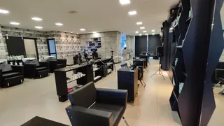 Um ambiente de escritório moderno com mesas e cadeiras escuras.