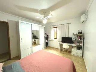 Quarto com armário branco e janela em um imóvel no Brasil.