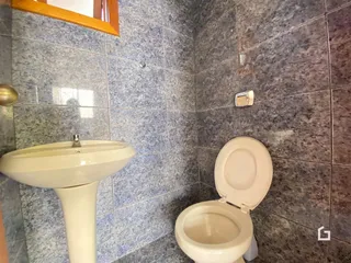 Interior de um banheiro com pia e vaso sanitário.