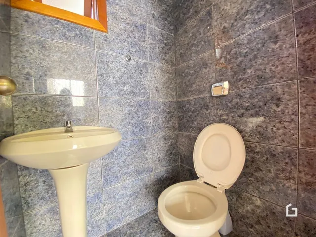 Interior de um banheiro com pia e vaso sanitário.