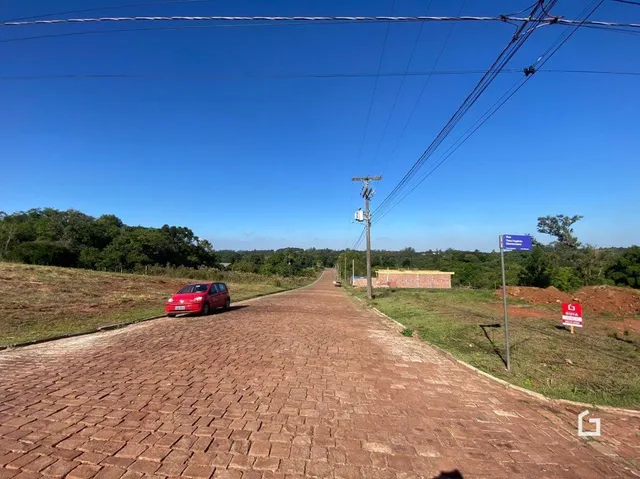 Uma estrada de terra leva a uma área gramada com árvores na propriedade.