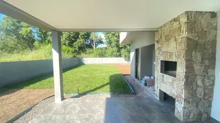 Vista externa de um jardim com gramado e área pavimentada em uma propriedade em Lajeado.