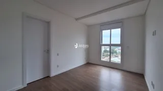 Vista interna de um ambiente com piso de madeira clara e paredes brancas.
