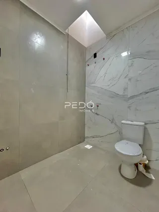 Foto de um banheiro com revestimento em mármore branco.