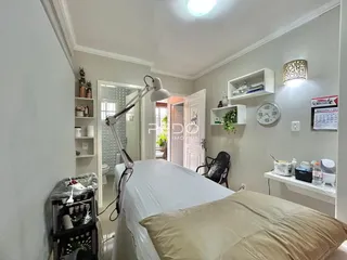 Quarto com cama e estantes brancas em um imóvel no Brasil