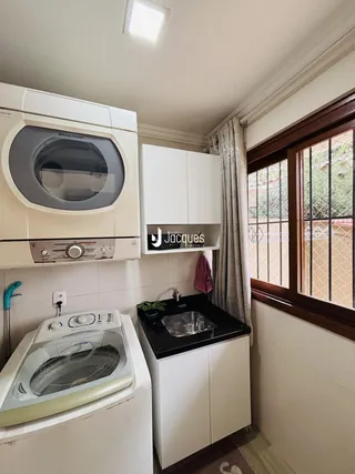 Foto de uma cozinha com armários brancos e eletrodomésticos.