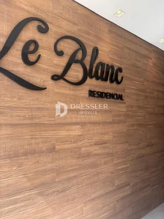 Detalhe da parede com o nome do residencial e da imobiliária.