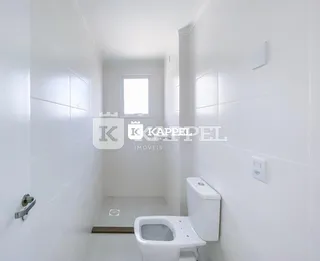 Foto de um banheiro interno com paredes brancas e um vaso sanitário.