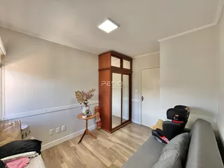 Ambiente interno de uma sala com piso de madeira e um armário de madeira.