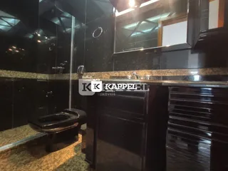 Foto de uma cozinha com armários escuros e bancada de granito.