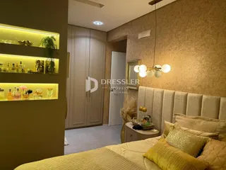Quarto com cabeceira estofada e prateleiras decorativas na sala.