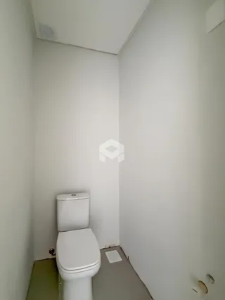 Foto de um corredor interno com um vaso sanitário.