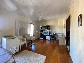 Sala de estar com piso de madeira e paredes brancas.