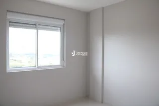 Vista interna de um cômodo com janela em uma residência.