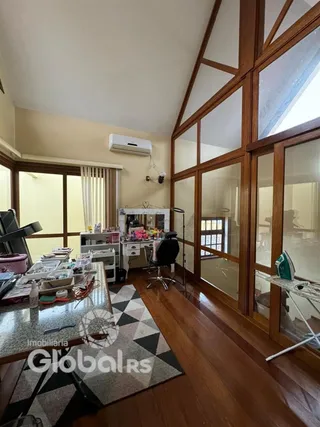 Sala de estar com piso de madeira e grandes janelas em um imóvel no Brasil.