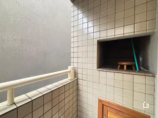 Uma parede com azulejos claros e um corrimão branco são visíveis na imagem.