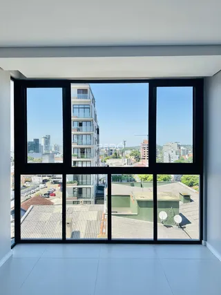 Vista da janela de um imóvel em Lajeado, Brasil, mostrando edifícios vizinhos.