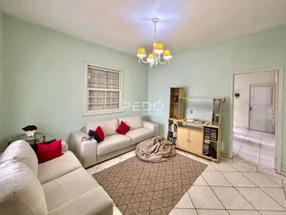 Sala de estar com sofás brancos e piso de cerâmica clara.