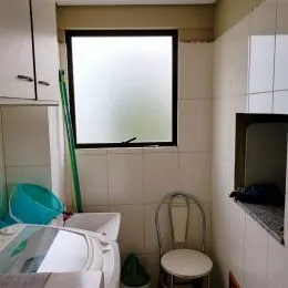 Foto interna de uma cozinha com armários e janela.