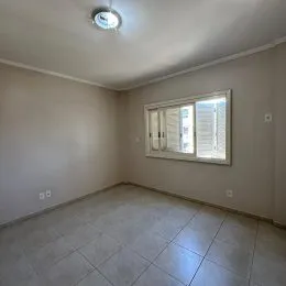 Ambiente interno com piso de cerâmica e janela na sala.