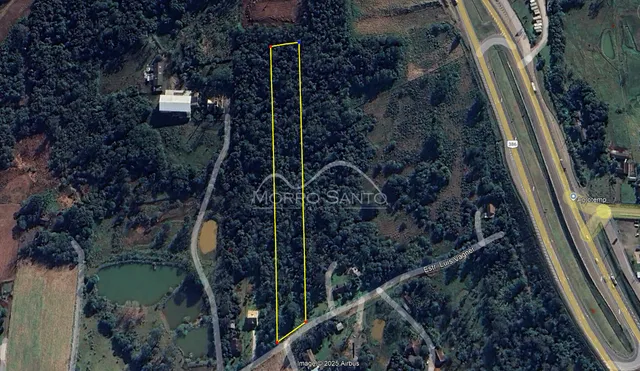 Vista aérea de uma propriedade rural com vegetação densa e áreas abertas.