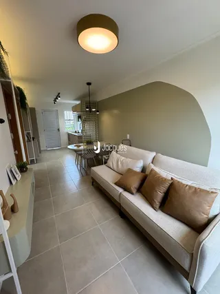 Sala de estar com sofá e área de jantar em um apartamento.