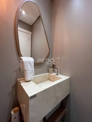 Foto de um banheiro com bancada de pedra e espelho.