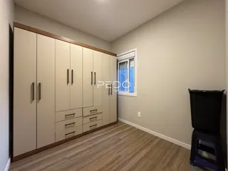 Quarto com armários embutidos e piso de madeira clara.