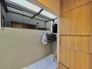 Vista interna de um corredor com parede de madeira e piso de cerâmica.