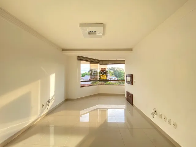 Interior de uma sala com piso de cerâmica clara e paredes brancas.
