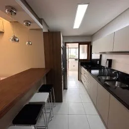Corredor interno com piso de cerâmica e detalhes em madeira.