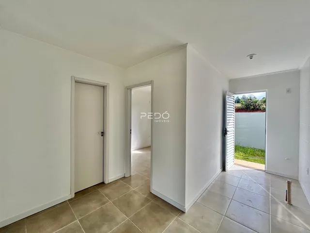 Hall de entrada com piso de cerâmica claro.