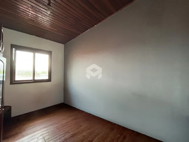 Vista interna de um cômodo com piso de madeira e teto de madeira.