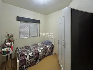 Quarto com janela e armário em ambiente residencial.