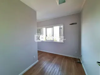 Foto de um corredor com piso de madeira e janela.