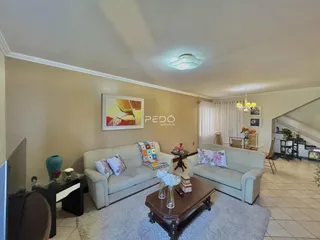 Sala de estar com sofá e decoração de paredes claras.