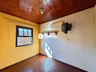 Ambiente interno com piso de madeira e teto de tábuas de madeira.