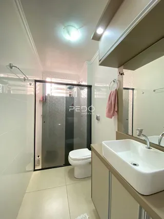 Foto de um banheiro com piso claro e azulejos brancos.