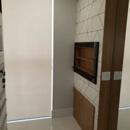 Foto de um corredor interno com paredes brancas e revestimento de azulejos.