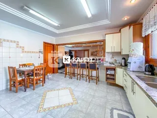Cozinha com armários de madeira e piso de cerâmica em um imóvel.