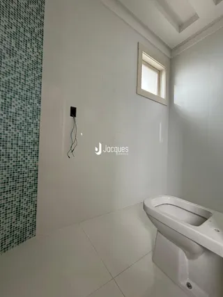 Foto de um banheiro com piso de cerâmica e parede revestida.