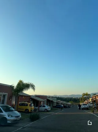 Vista da rua em Lajeado, Brasil, mostrando casas e veículos estacionados.