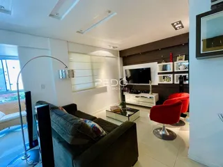 Sala de estar com sofá e televisão em um apartamento no Brasil.
