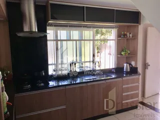 Vista da cozinha com armários escuros e janela.