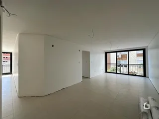 Ambiente interno de uma sala com piso de cerâmica e paredes brancas.