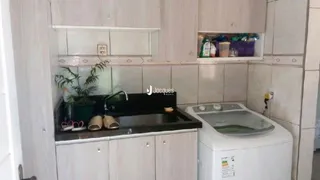 Armários de cozinha brancos com bancada escura e pia na Lajeado, Brasil.